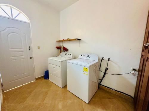 a laundry room with a refrigerator and a washer and dryer at Villa Tropical Cabarete in Sosua