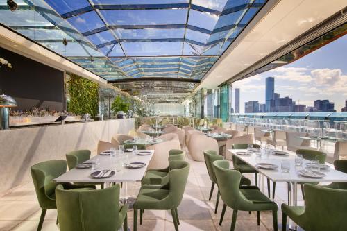 a restaurant with white tables and chairs and a glass ceiling at Emporium Hotel South Bank in Brisbane