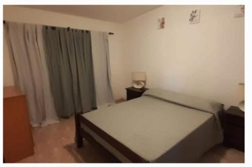 a bedroom with a white bed and a window at El Tito Alojamiento in San Roque