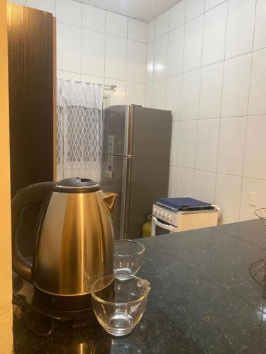 a tea kettle on a counter in a kitchen at Casa completa com dois quartos e estacionamento grátis in Serra