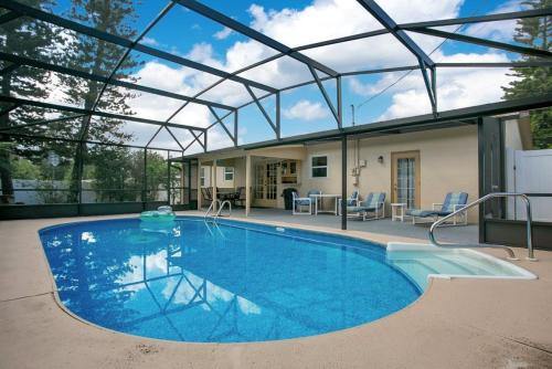 a large swimming pool with a glass roof at Home away from Home! in Deltona