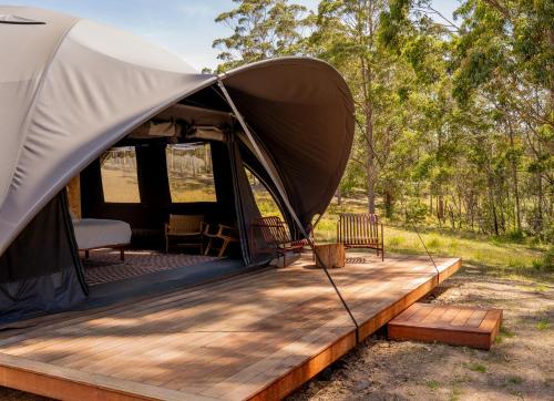 a tent with a wooden deck in a field at Mimosa Wines in Murrah
