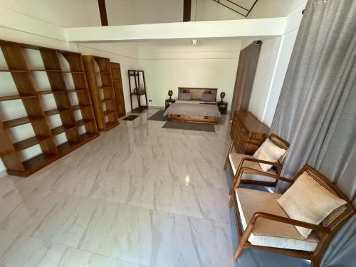 a large room with a bed and two chairs at 108 Palms Beach Resort in Trincomalee