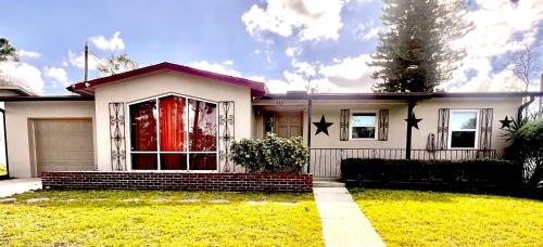 a white house with a red door and a grass yard at Home away from Home! in Deltona