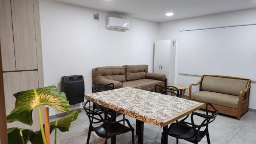 een woonkamer met een tafel en stoelen bij Departamentos Hilario Lagos in Viedma