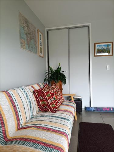 a couch with pillows on it in a living room at Central Diamond Harbour Guest Suite in Diamond Harbour