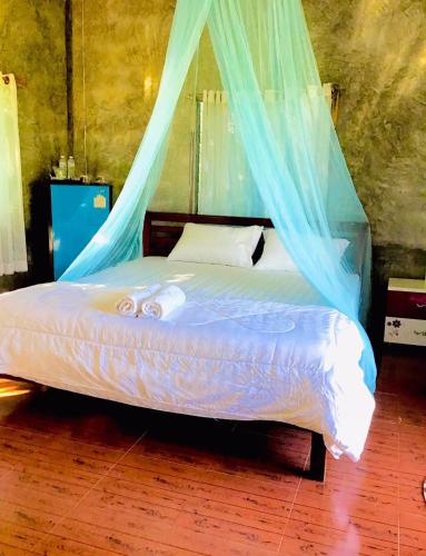 a bedroom with a bed with a mosquito net at DoiLom Farmstay in Ban Muang Kut