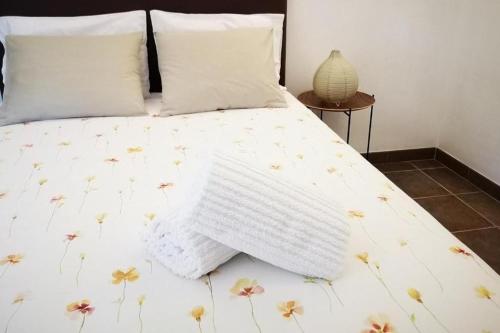a bed with a white comforter with flowers on it at Sobreiro's Villa in Douro Valley in Mesão Frio