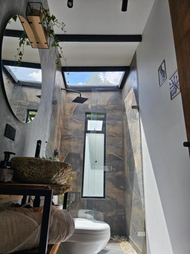 a bathroom with a toilet and a sink and a mirror at Equilibrium glamping in Guarne