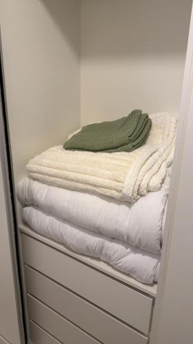 a stack of white towels sitting on a shelf at Lujoso Apartamento en edificio frente a la playa San José! in Encarnación