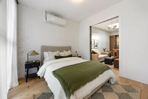 a bedroom with a large bed and a white brick wall at The Brick Hotel - The Loft in Toronto