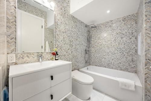 a bathroom with a sink and a toilet and a bath tub at The Brick Hotel - The Loft in Toronto