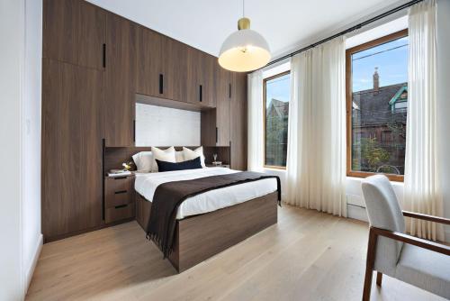 a bedroom with a bed and a desk and windows at The Brick Hotel - The Second Suite in Toronto