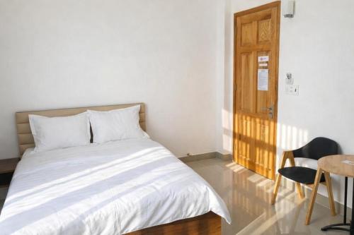 een slaapkamer met een bed, een tafel en een deur bij Hà Linh Hotel Vũng Tàu in Bà Rịa
