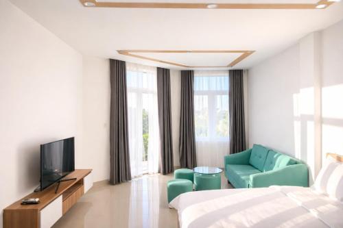 een hotelkamer met een bed, een tv en een stoel bij Hà Linh Hotel Vũng Tàu in Bà Rịa