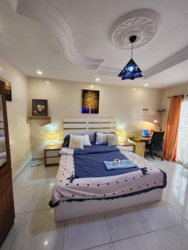 a bedroom with a large bed and a desk at STUDIO NGOR ALAMADIES BAKU plus in Dakar