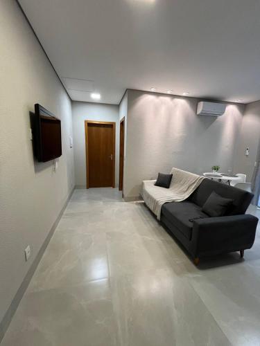a living room with a couch and a television at Atalaia Apart in Sinop