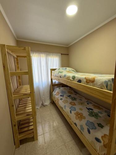 a bedroom with two bunk beds and a window at Complejo Génesis in San José