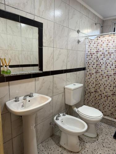 a bathroom with a sink and a toilet and a mirror at Complejo Génesis in San José