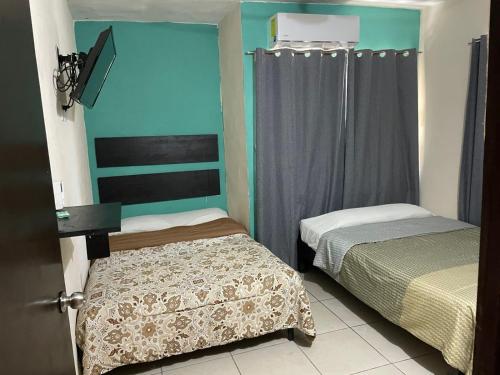 a small room with two beds and a window at Hotel en Acapulco Bora Bora in Acapulco