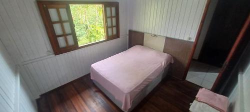 a small room with a small bed and a window at Chácara mobiliada próximo Criciúma Br101 in Araranguá