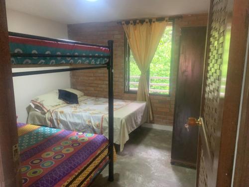 a bedroom with two bunk beds and a window at Casa Lucy in Yumbo