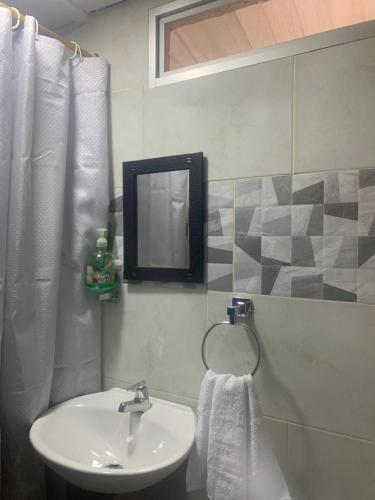 a bathroom with a sink and a mirror at Casa Lucy in Yumbo