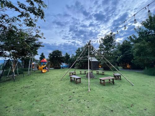 a park with benches and a swing set at Chavallee Campground in Ban Tha Chang