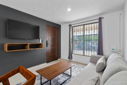 a living room with a couch and a large window at Elegante Casa Completa. Merida, Yucatan / House MR in Mérida
