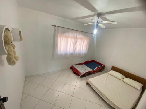 a room with a bed and a ceiling fan at Apartamento em Itapemirim in Itapemirim
