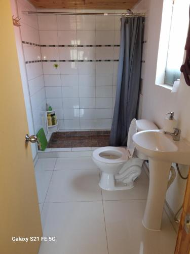 a bathroom with a toilet and a sink at Casa de descanso in Paredones