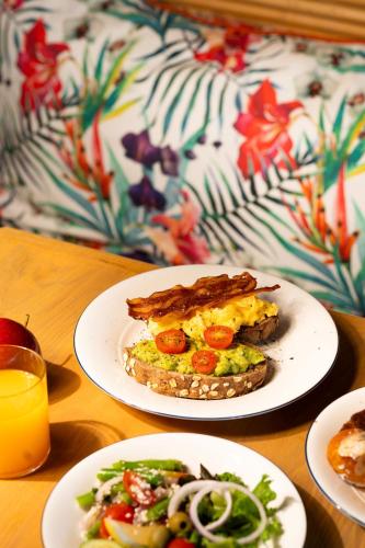 ein Tisch mit zwei Tellern Essen und einem Glas Orangensaft in der Unterkunft The Standard, Hua Hin in Hua Hin