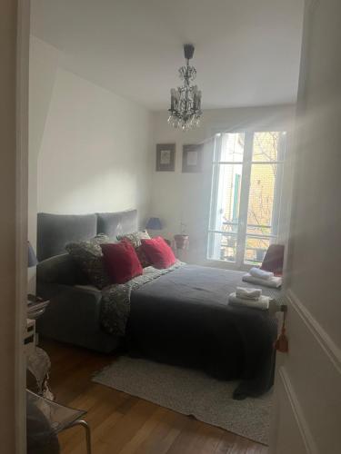 een slaapkamer met een bed en een kroonluchter bij Bedroom in Paris in Parijs