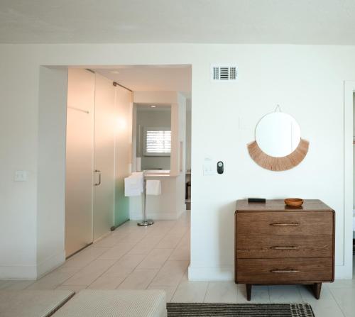 a bathroom with a wooden dresser and a mirror at Suites by The Wellborn in Orlando