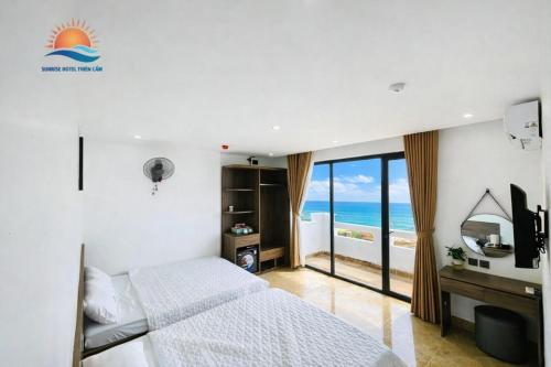 a bedroom with a bed and a view of the ocean at Sunrise Hotel Thiên Cầm in Ha Tinh