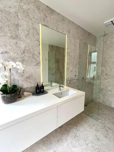 a bathroom with a white sink and a mirror at Portsea Paramount - When only the best will do in Portsea