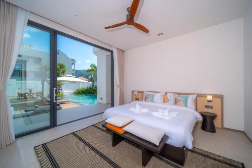 a bedroom with a large bed and a balcony at Étoile Kata Luxury Pool Villas by Astra in Kata Beach