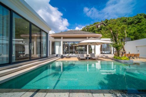 a swimming pool in a house with glass walls at Étoile Kata Luxury Pool Villas by Astra in Kata Beach