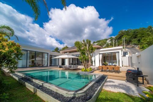 an exterior view of a house with a swimming pool at Étoile Kata Luxury Pool Villas by Astra in Kata Beach