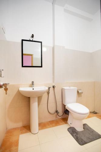 a bathroom with a sink and a toilet and a mirror at 75 Inn Madiha in Matara