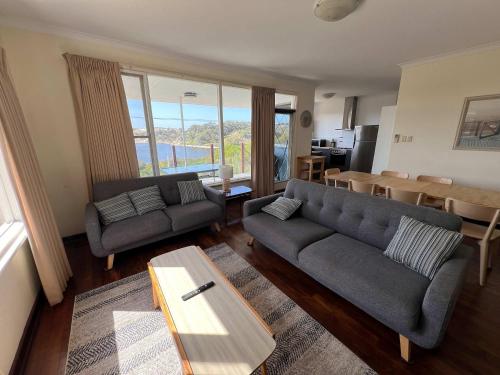 een woonkamer met een bank en een tafel bij River Panorama Beach House in Guilderton