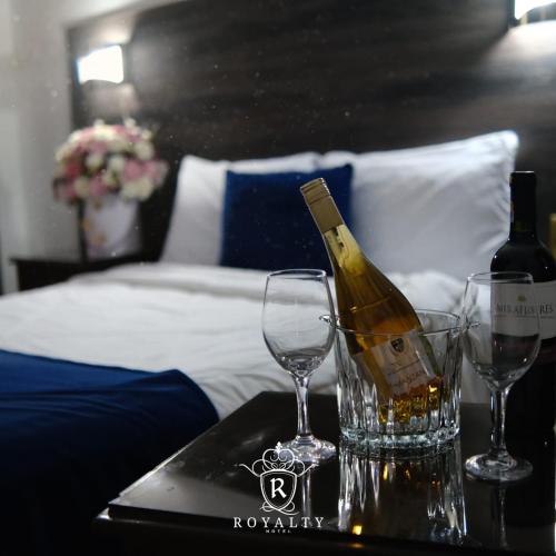 Eine Flasche Wein und zwei Gläser auf einem Tisch in der Unterkunft Hotel Royalty in Riobamba