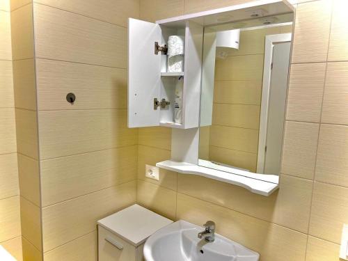 łazienka z umywalką i lustrem w obiekcie Bazaar Center Studio w Tiranie