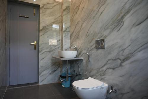 a bathroom with a white toilet and a sink at Jagir villa in Udaipur