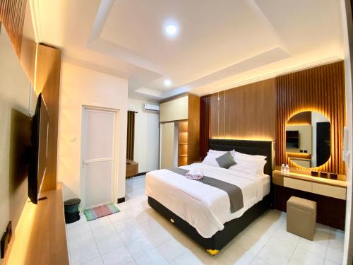 a bedroom with a large bed and a large mirror at Kalandra Living in Yogyakarta