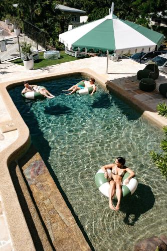a group of people swimming in a swimming pool at Victoria Street Boutique Hotel Townsville in Townsville