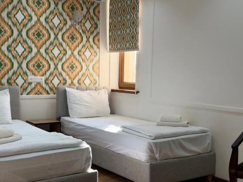 ein Zimmer mit zwei Betten und einem Fenster in der Unterkunft Ulli Oy Boutique Hotel & Terrace in Xiva