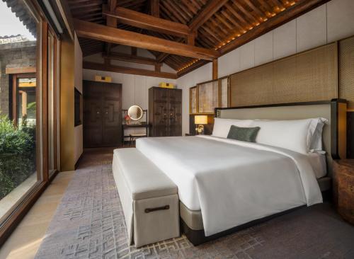 una camera da letto con un letto grande e una grande finestra di Mandarin Oriental Qianmen, Beijing a Pechino