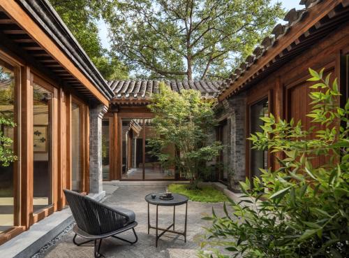 un cortile di una casa con una sedia e un tavolo di Mandarin Oriental Qianmen, Beijing a Pechino