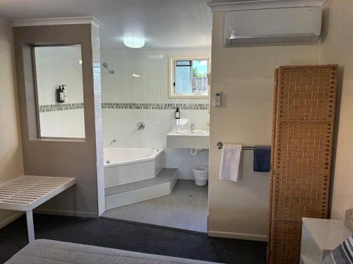 a bathroom with a tub and a sink at Shady Rest Motel in Gympie